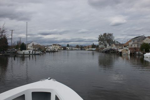 1990 Ford Bronco - A waterway lined with houses and docked boats under a cloudy sky.