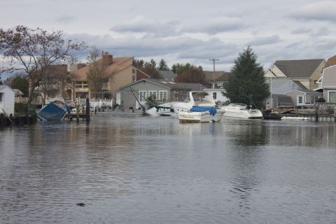 1990 Ford Bronco - Several boats are moored in the water, with some houses in the background showing signs of flooding.