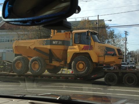 1990 Ford Bronco - A yellow articulated dump truck, identified as MT 31, is transported on a flatbed trailer.