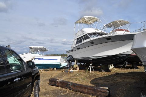 1990 Ford Bronco - Multiple boats are stored on land, with a black truck in the foreground.