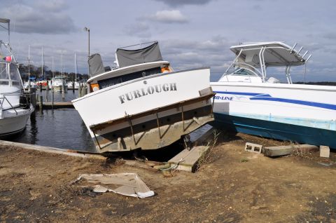 1990 Ford Bronco - Boats sit aground on the shore near a marina, with one vessel clearly marked 'Furlough'.