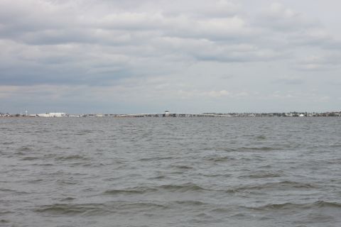 1990 Ford Bronco - A wide shot of choppy water with a distant urban shoreline under a cloudy sky.