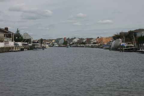 1990 Ford Bronco - Waterway with houses and boats on either side under a cloudy sky.