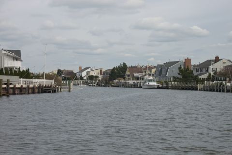 1990 Ford Bronco - A view of a canal with houses and boats docked along the sides under a cloudy sky.