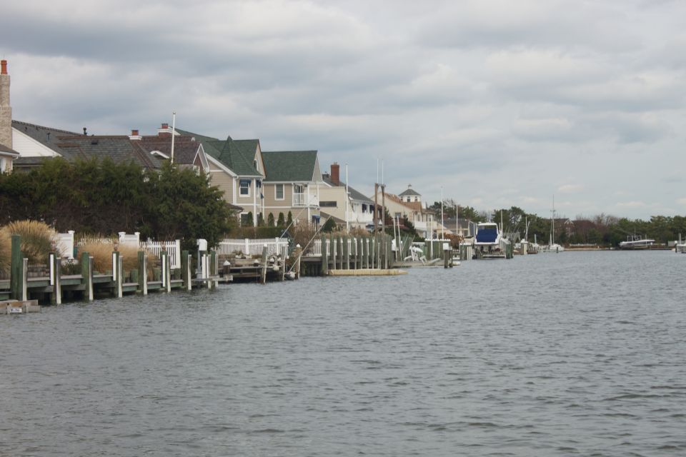 Waterway with houses and docks, a blue boat is visible in the distance