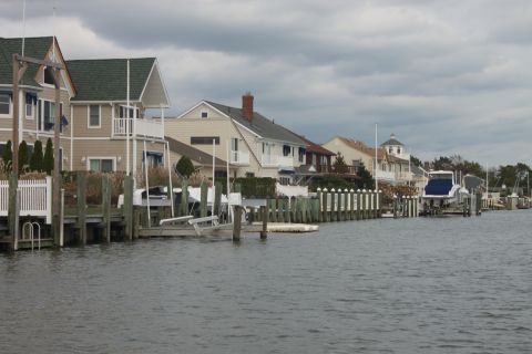 1990 Ford Bronco - Waterfront houses line the canal, with docks and boats visible.