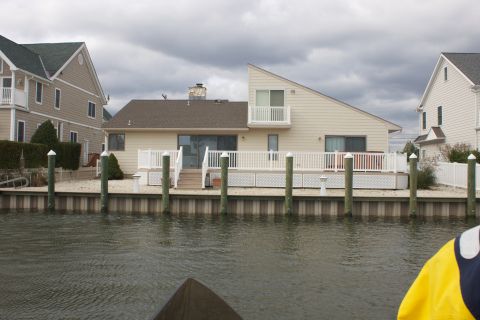1990 Ford Bronco - Houses line a canal, with a cloudy sky overhead.