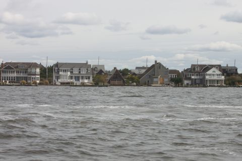 1990 Ford Bronco - A waterfront view shows several houses lining the shore under an overcast sky.
