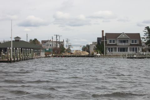 1990 Ford Bronco - A waterfront scene shows houses and docks with choppy water in the foreground under a cloudy sky.
