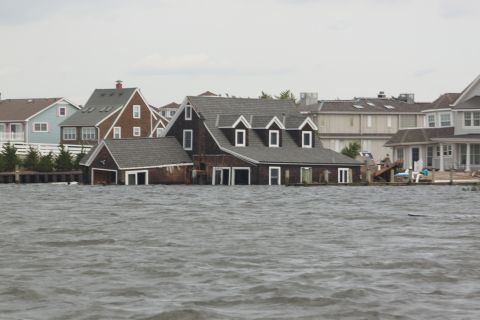 1990 Ford Bronco - Waterfront homes submerged during a flood event, with visible damage to structures.
