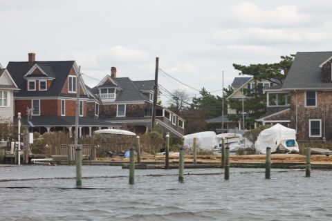 1990 Ford Bronco - Several boats are covered and stored near waterfront homes under an overcast sky.