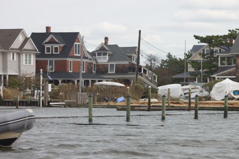 1990 Ford Bronco - An inflatable boat floats on choppy water in front of waterfront houses.