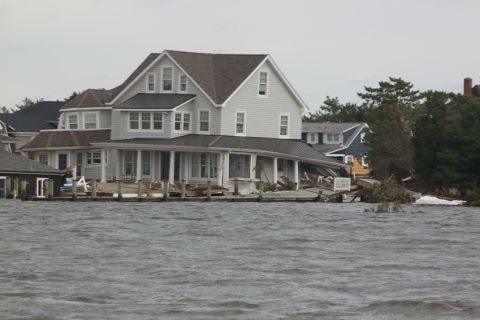 1990 Ford Bronco - Waterfront homes damaged by flooding, with debris visible on the shore.