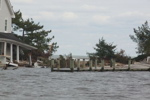 1990 Ford Bronco - Coastal scene after a storm shows a damaged house and pier with high water levels.