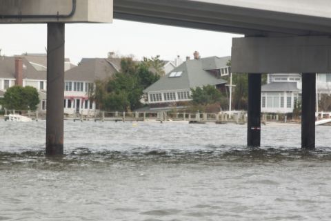 1990 Ford Bronco - Waterfront homes submerged during a flood event, seen from beneath a bridge structure.