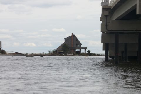 1990 Ford Bronco - Water surrounds a house and pier supports under an overcast sky.
