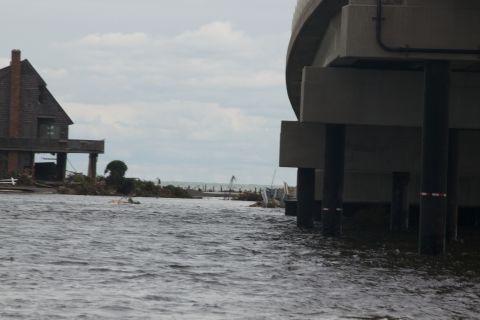 1990 Ford Bronco - A scene of destruction and flooding, with a house on stilts and bridge pilings visible in the aftermath of a storm.