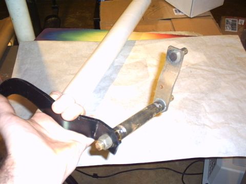 1991 Ford LTD Crown Victoria - Brake pedal assembly with metal linkage being held by a hand.