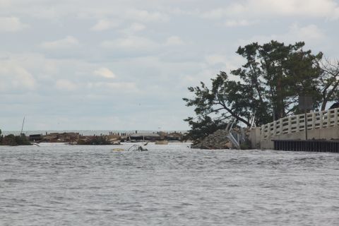 1990 Ford Bronco - The aftermath of a major storm shows widespread destruction and flooding, with debris scattered across the water.