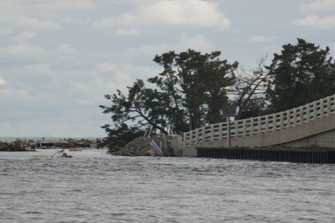 1990 Ford Bronco - A scene of destruction shows a damaged bridge and debris in the aftermath of a storm.
