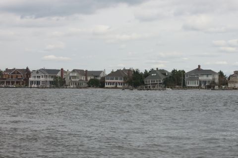 1990 Ford Bronco - A row of houses sits along the water under a cloudy sky.