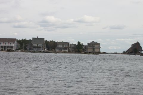 1990 Ford Bronco - A view of waterfront houses along a body of water under a cloudy sky, with a watermark at the bottom right.