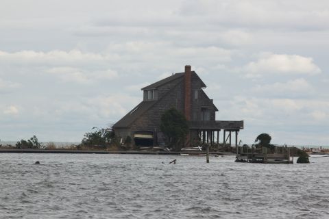 1990 Ford Bronco - House on stilts surrounded by water, likely damaged by a storm.