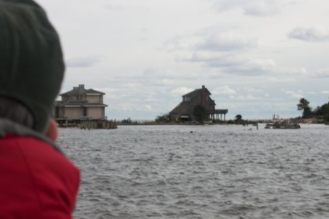 1990 Ford Bronco - Houses submerged in water, likely due to a storm, with a person in the foreground.