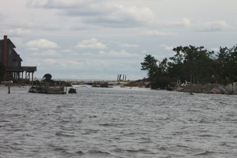1990 Ford Bronco - Coastal area devastated by flooding, showing damaged structures and debris scattered across the water.
