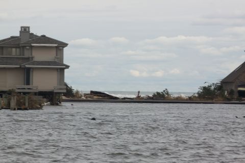 1990 Ford Bronco - Coastal flooding and damage after a storm, with houses partially submerged and debris scattered.