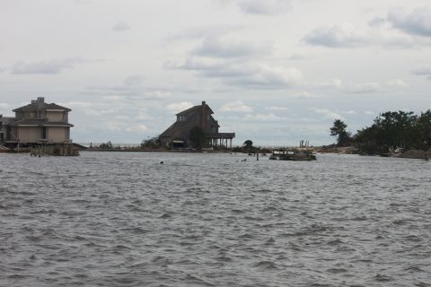 1990 Ford Bronco - Coastal flooding aftermath shows houses on stilts and debris in the water.