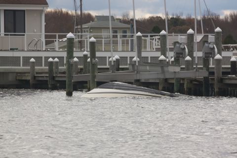 1990 Ford Bronco - Boat partially submerged in water near a dock after an event.