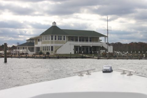1990 Ford Bronco - View from a boat's bow shows a marina and a large building under a cloudy sky. The website Supermotors.net is visible.