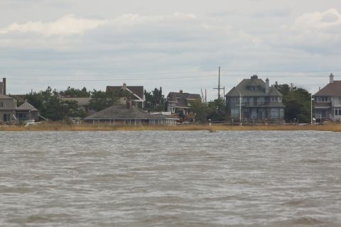 1990 Ford Bronco - A view of coastal homes and vegetation from the water, under an overcast sky.
