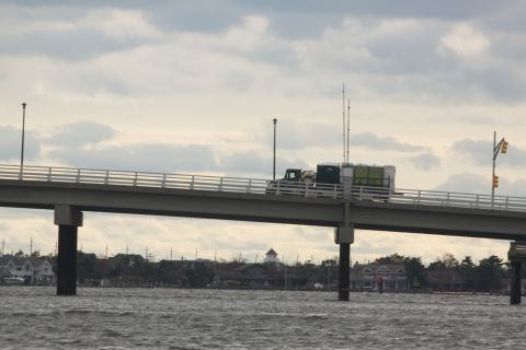1990 Ford Bronco - Truck with cargo on a bridge under a cloudy sky.