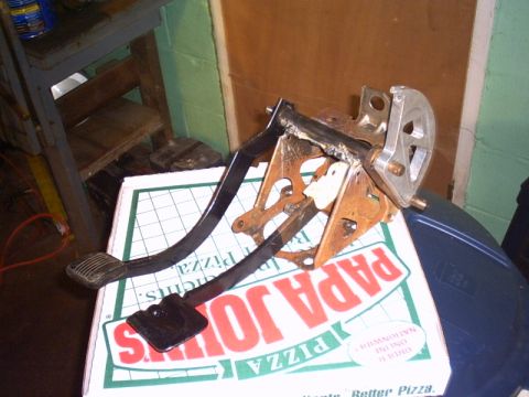 1991 Ford LTD Crown Victoria - A car's pedal assembly, likely for brake and gas, rests on a Papa John's pizza box.