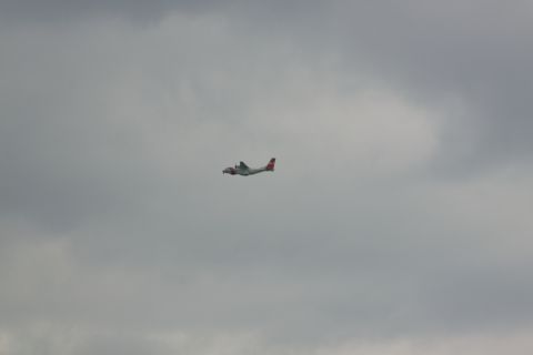 1990 Ford Bronco - An airplane flies through a cloudy sky, with the Supermotors logo visible at the bottom right.