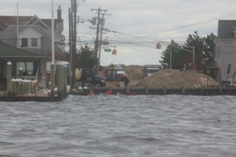 1990 Ford Bronco - Construction equipment is visible on a dock, with debris and choppy water surrounding the area.