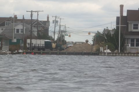 1990 Ford Bronco - Waterfront scene showing flooded homes and construction activity after a storm.