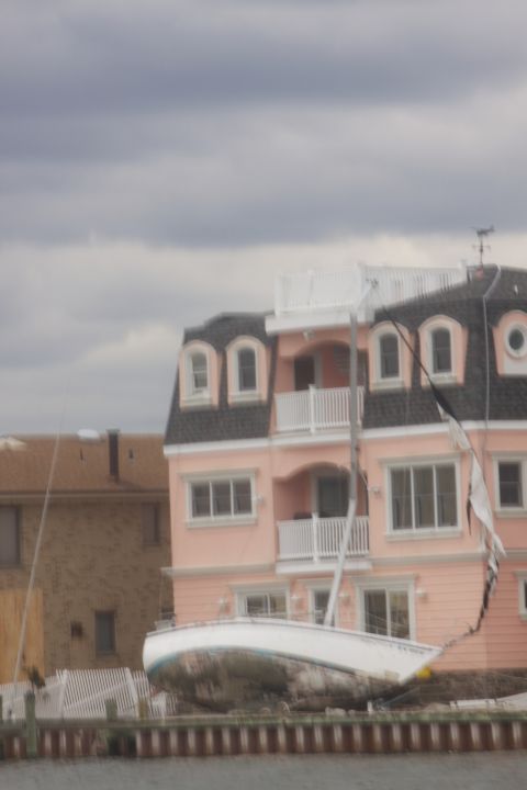 1990 Ford Bronco - A sailboat sits ashore near residential buildings, possibly after a storm.