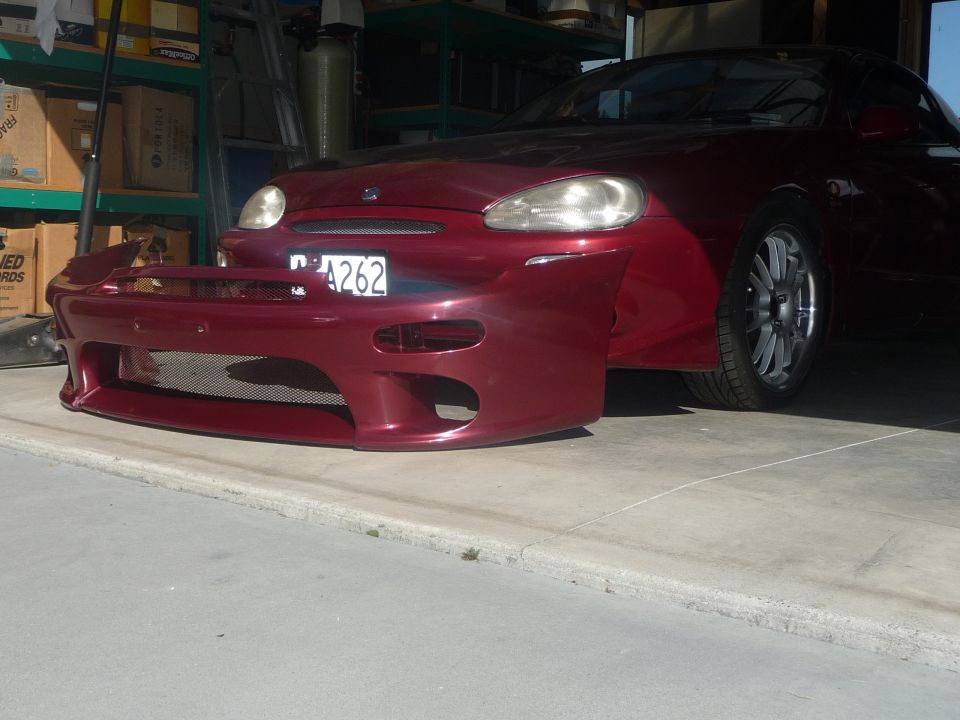 Red Mazda MX-3 front bumper cover with mesh grille and license plate area