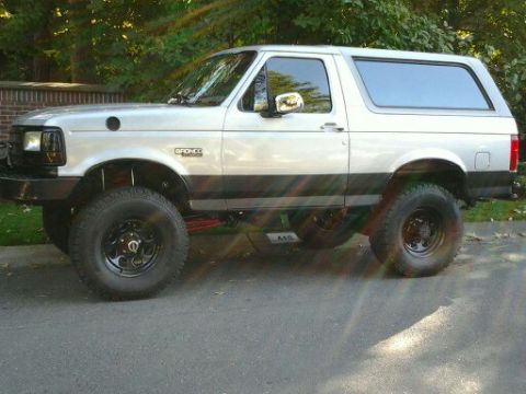 1996 Ford Bronco - This lifted 1996 Ford Bronco is shown from the side, its two-tone paint and large tires.