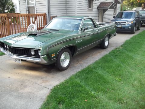 1970 Ford Ranchero - A green 1970 Ford Ranchero is parked on a driveway, with other vehicles visible behind it.