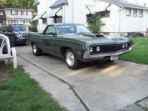 1970 Ford Ranchero - Green 1970 Ford Ranchero with aftermarket wheels and hood scoop parked on a concrete driveway.