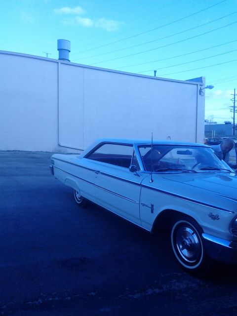 1960 Ford Falcon - A white 1963 Ford Galaxie 500 is seen from the front quarter angle, parked in front of a light-colored building.