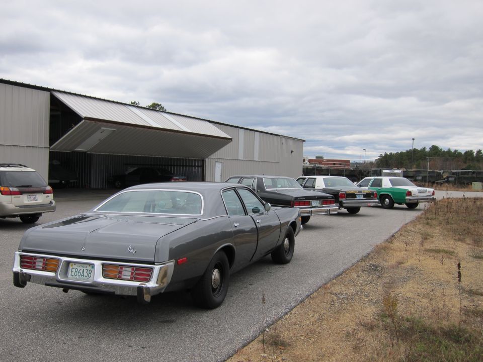 Gray sedan with a license plate E86A38, parked in a line of cars