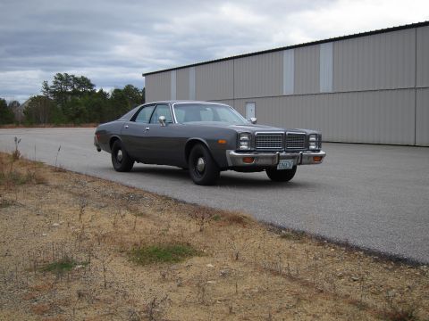 1991 Ford LTD Crown Victoria - This 1977 Dodge Monaco sedan is seen parked on an asphalt lot in front of a large industrial building.