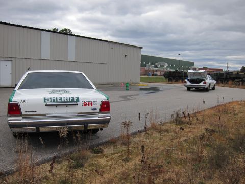 1991 Ford LTD Crown Victoria - A white 1991 Ford Crown Victoria LTD sheriff car is parked in front of a building, with another vehicle in the distance.