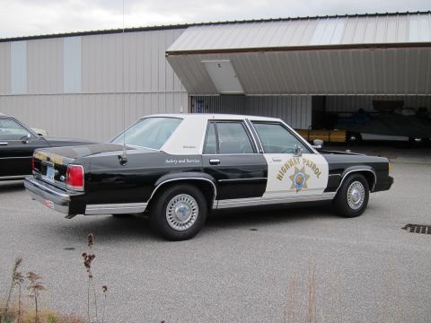 1991 Ford LTD Crown Victoria - This 1991 Ford Crown Victoria LTD, marked as Highway Patrol, is seen in a three-quarter front view next to another vehicle.