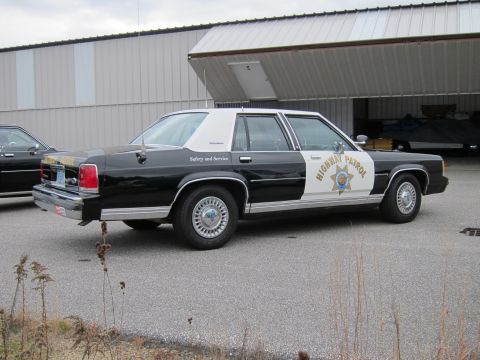 1991 Ford LTD Crown Victoria - Side view of a black and white 1991 Ford Crown Victoria LTD highway patrol car.